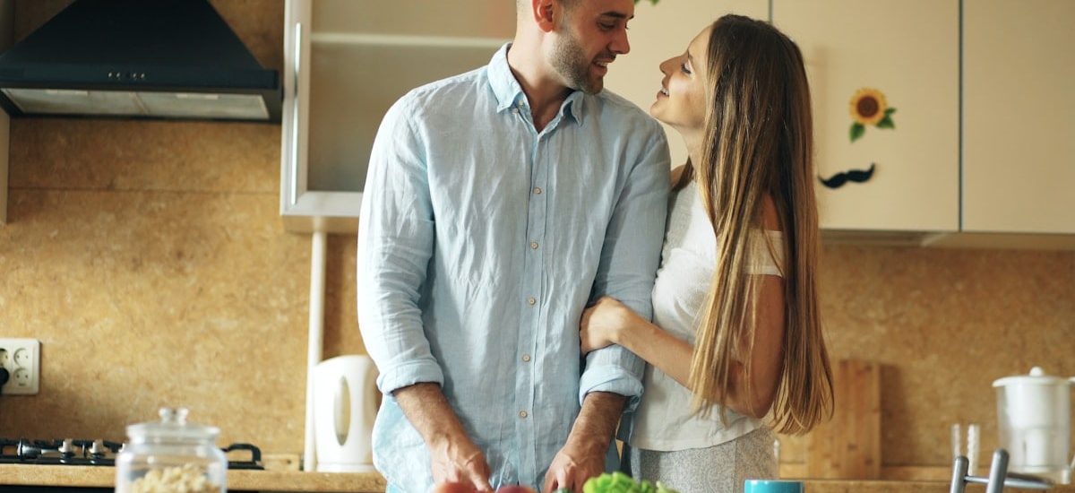 Portrait of loving couple cooking breakfast smiling in the kitchen at home