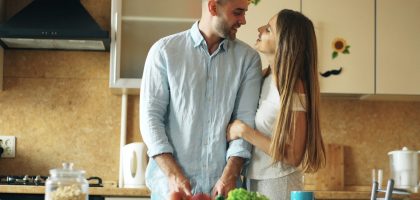 Portrait of loving couple cooking breakfast smiling in the kitchen at home