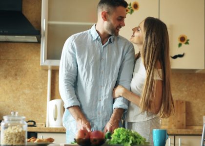 Portrait of loving couple cooking breakfast smiling in the kitchen at home
